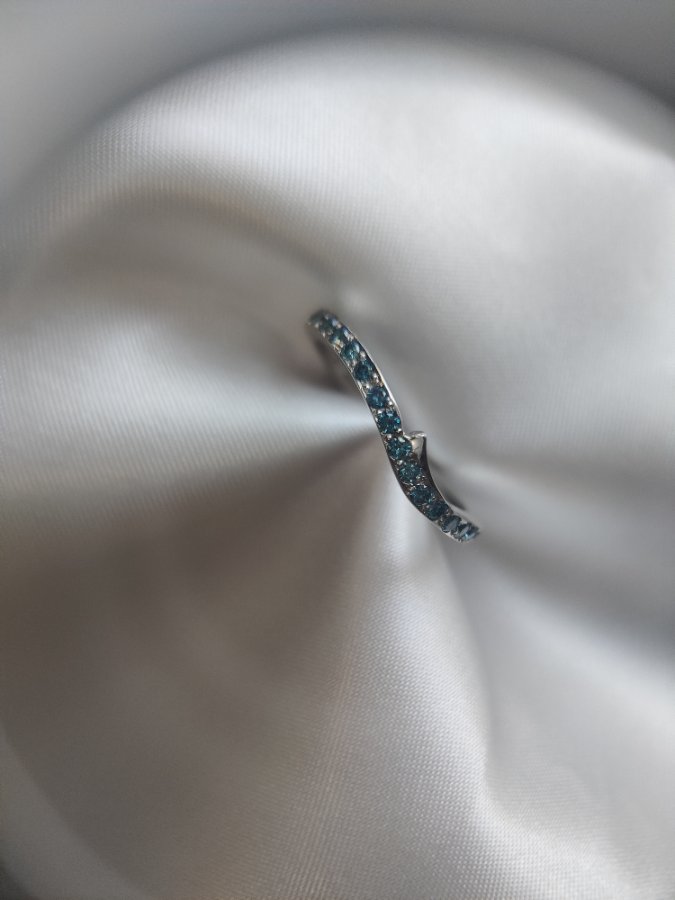 Contoured wedding band with blue diamonds